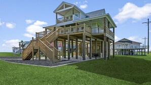 A two-story beachfront house with a wooden deck and a staircase leading to the upper level.