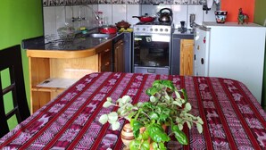 Een kleine keuken met houten kastjes, een fornuis en een koelkast.