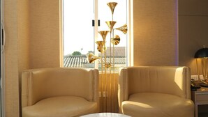 A room with two leather armchairs, a modern floor lamp, and a window with a view of traditional architecture. - A boutique hotel, situated in the middle of Nigeria's commercial capital Lagos. (Lagos)