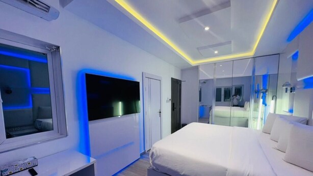 A modern bedroom with a large bed, a TV, and a wardrobe. - A boutique hotel, situated in the middle of Nigeria's commercial capital Lagos. (Lagos)