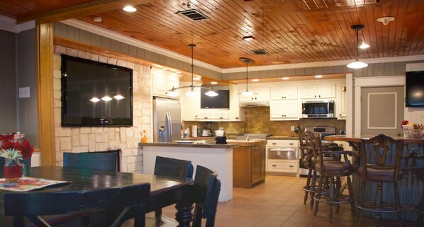 A modern kitchen with wooden ceiling, built-in appliances, and a large island. - Duplex Style Cabin on Lake Texoma: Cabin 206 (Denison)