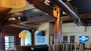 Un espace salon confortable avec un canapé en cuir, une table en bois et un écran de télévision.