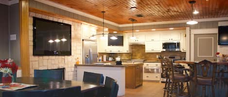 Una cocina moderna con techo de madera, electrodomésticos integrados y una isla grande.
