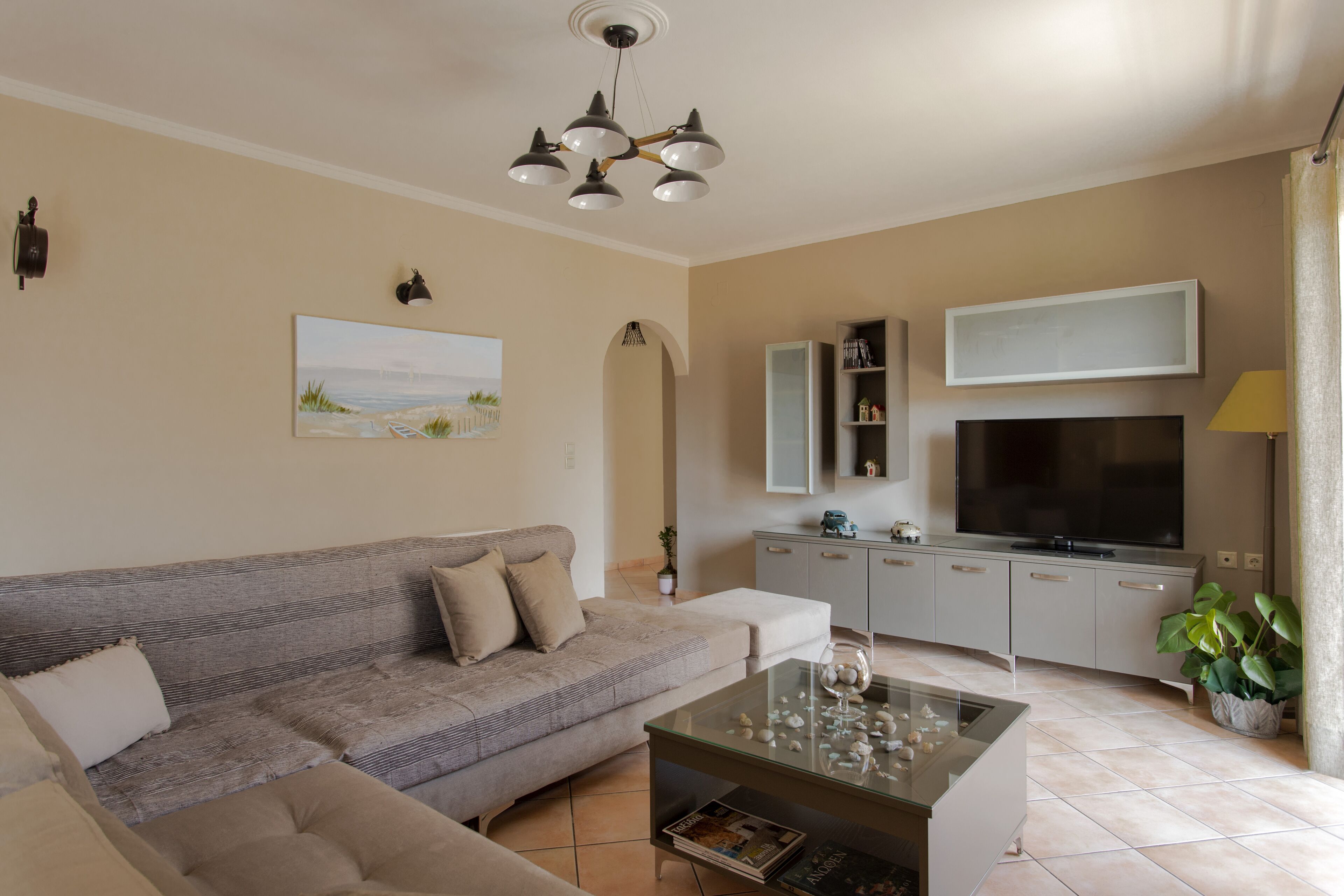 A living room with a sofa, coffee table, TV, and cabinets.