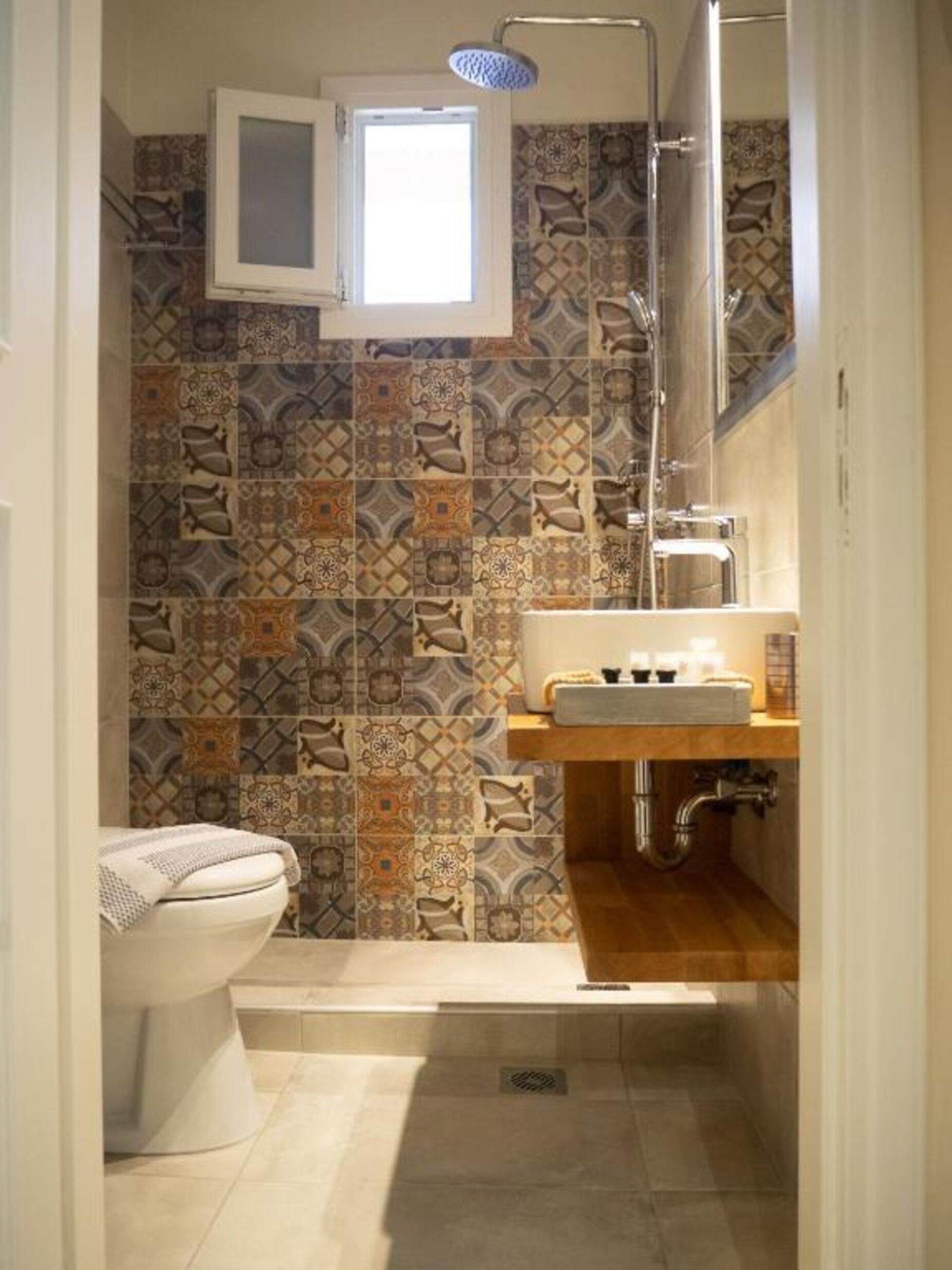 Un baño pequeño con ducha, inodoro y lavabo.