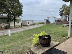 A grassy area with a potted plant and a concrete bench. - Quaint cabin at Little Mineral Marina: Cabin 4 (Pottsboro)