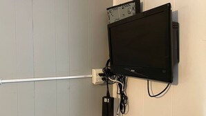 A wall-mounted television with a power strip and cables.