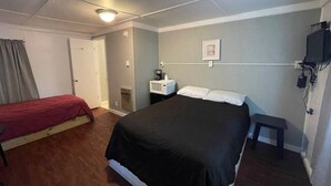 A room with a bed, a desk, a chair, and a television.