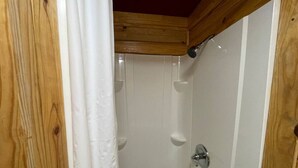 A wooden-framed shower with white walls and a white curtain. - Cozy Cedar Cabin at Mill Creek Marina: Cabin 3 (Pottsboro)
