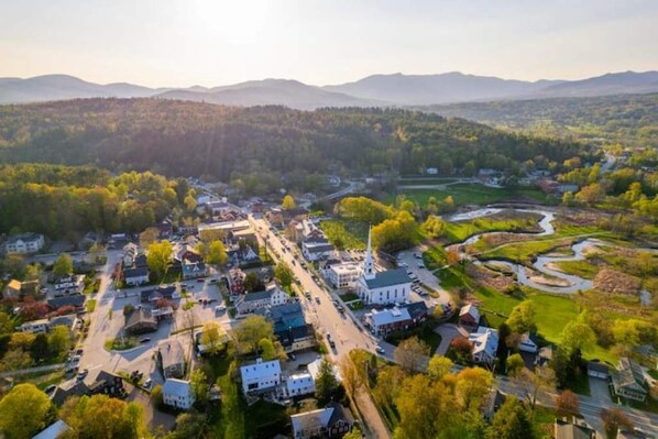 An aerial view of a town with a river, houses, and a church.