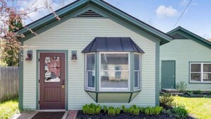 Ein eingeschossiges Haus mit Erkerfenster, Haustür und einer kleinen Veranda.