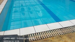 An indoor swimming pool with clear blue water, a tiled floor, and a metal roof structure. - Lux Suites Stunning Homes Kilimani (Nairobi)