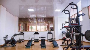 A gym with cardio machines, weightlifting equipment, and a mirrored wall. - Lux Suites Stunning Homes Kilimani (Nairobi)