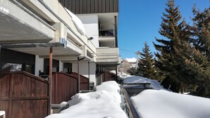 A multi-story building with a balcony on the second floor, surrounded by snow-covered ground and trees. - Sestriere apartment in residence with veranda (Sestriere)