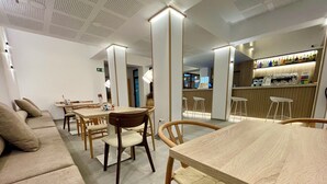 A modern interior with a dining area, sofas, and a bar. - La Hospederia - El Provencio (El Provencio)