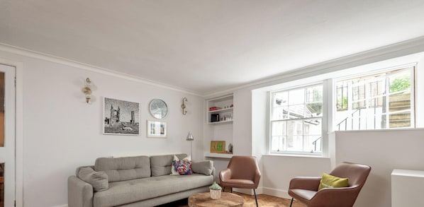 Un salon moderne avec un canapé, des fauteuils et une table basse.