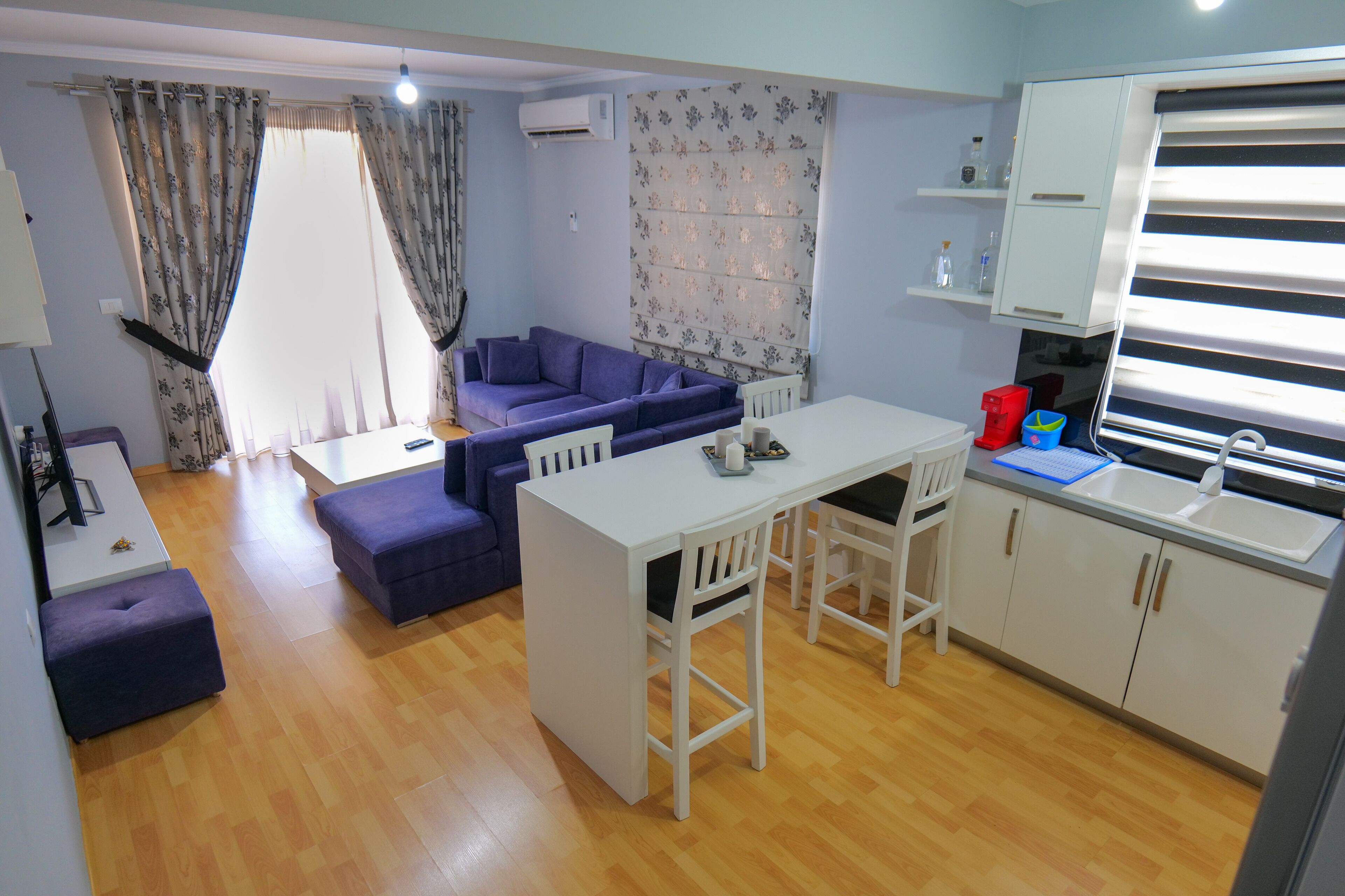 A compact living space with a sofa, dining table, and kitchenette.