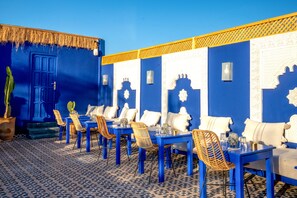 A blue and white interior with a patterned floor, tables, and chairs arranged for dining. - Riad Le Minaret and SPA (Marrakech)