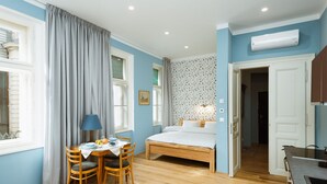 A bedroom with a bed, a desk with a chair, and a window with curtains.