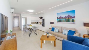 Ein modernes Wohnzimmer mit Sofa, Couchtisch und Essbereich.