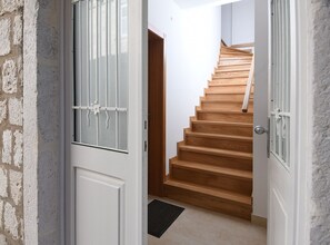 Stairs lead to a door on the left and a door on the right.