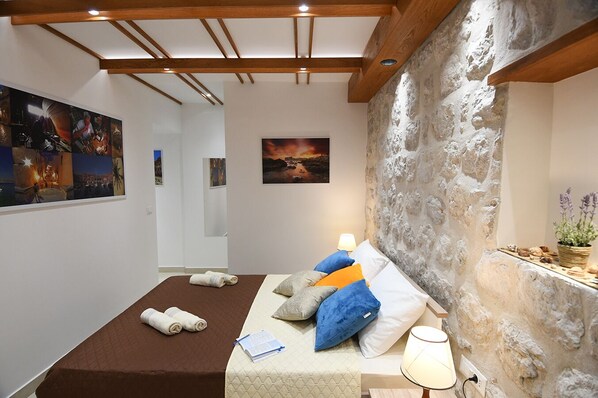 Cozy retreat with a large bed, table, and artwork adorning the walls.