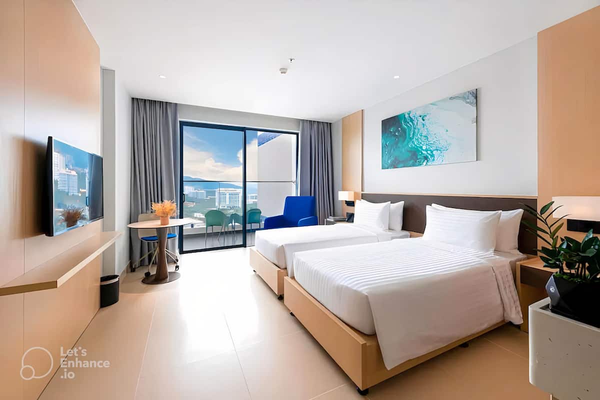 A modern hotel room with a large bed, a desk, a chair, and a view of the city.