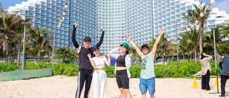 Un grupo de personas posando frente a un hotel moderno con una fachada curva distintiva.