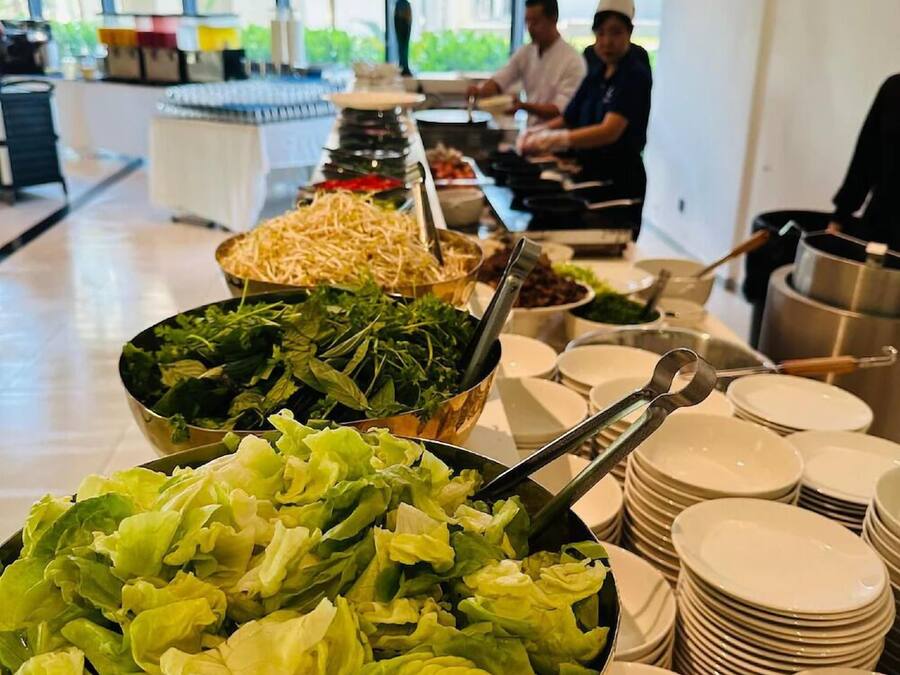 A buffet setup with various food items and stacked plates.