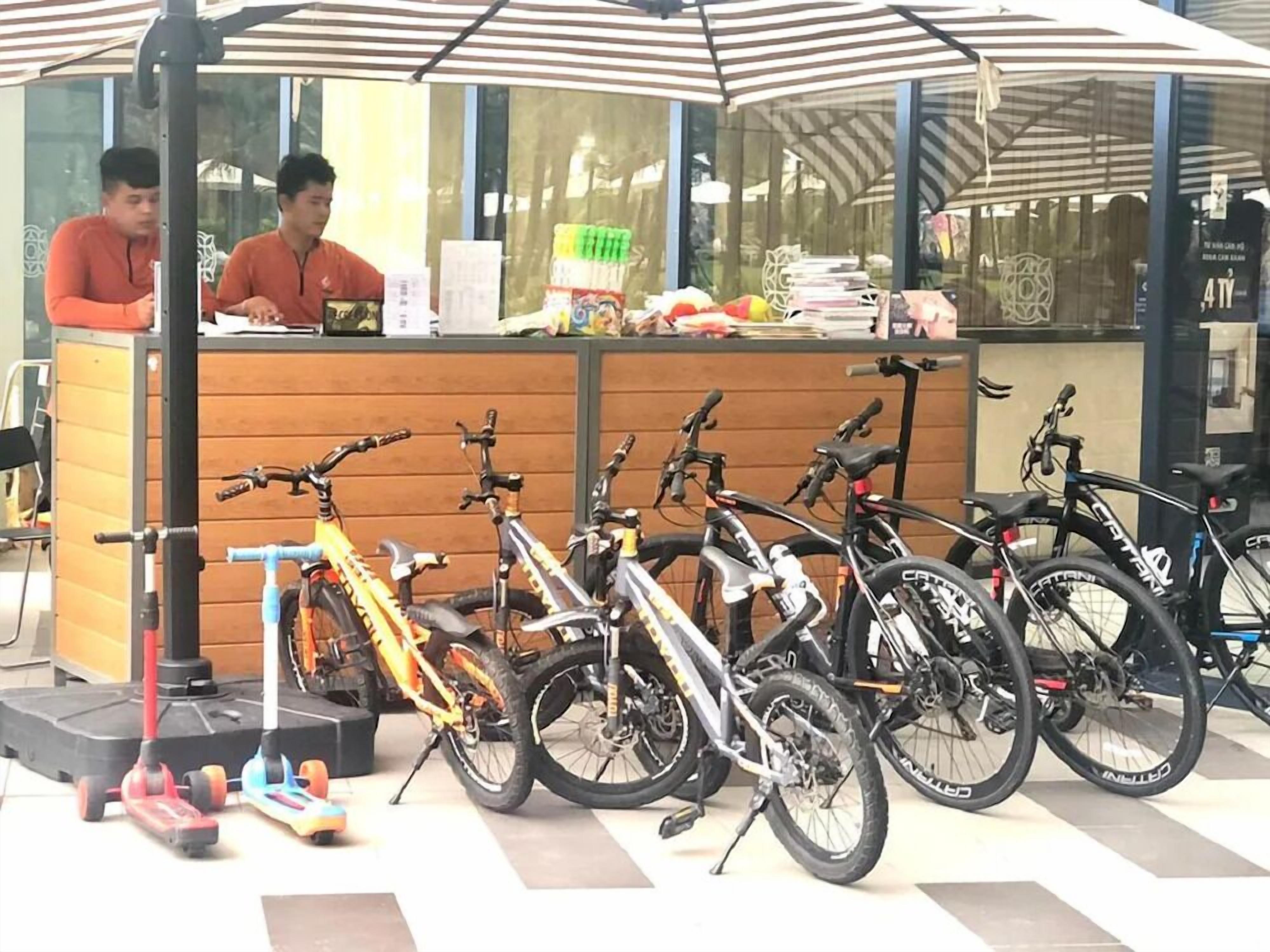 A bicycle rental station with multiple bicycles and a counter.