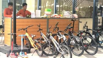A bicycle rental station with multiple bicycles and a counter.