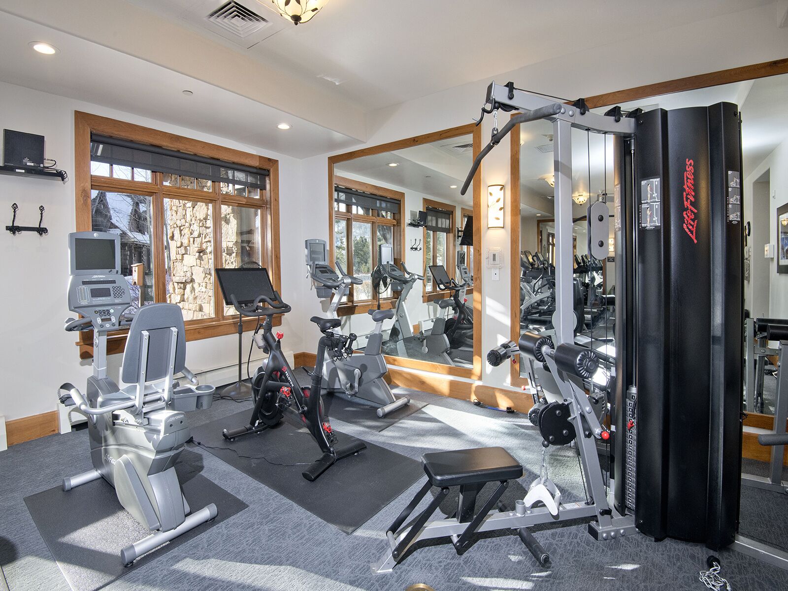 A gym with exercise equipment, a mirror, and a punching bag.