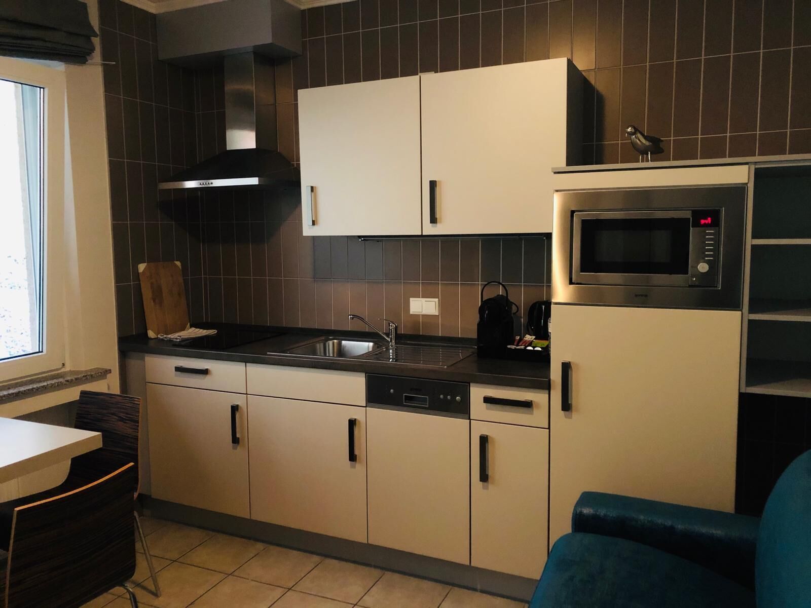 Una cucina moderna con forno a microonde, lavello e pensili.