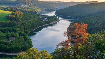 A river winding through a forested valley with houses along the riverbank.