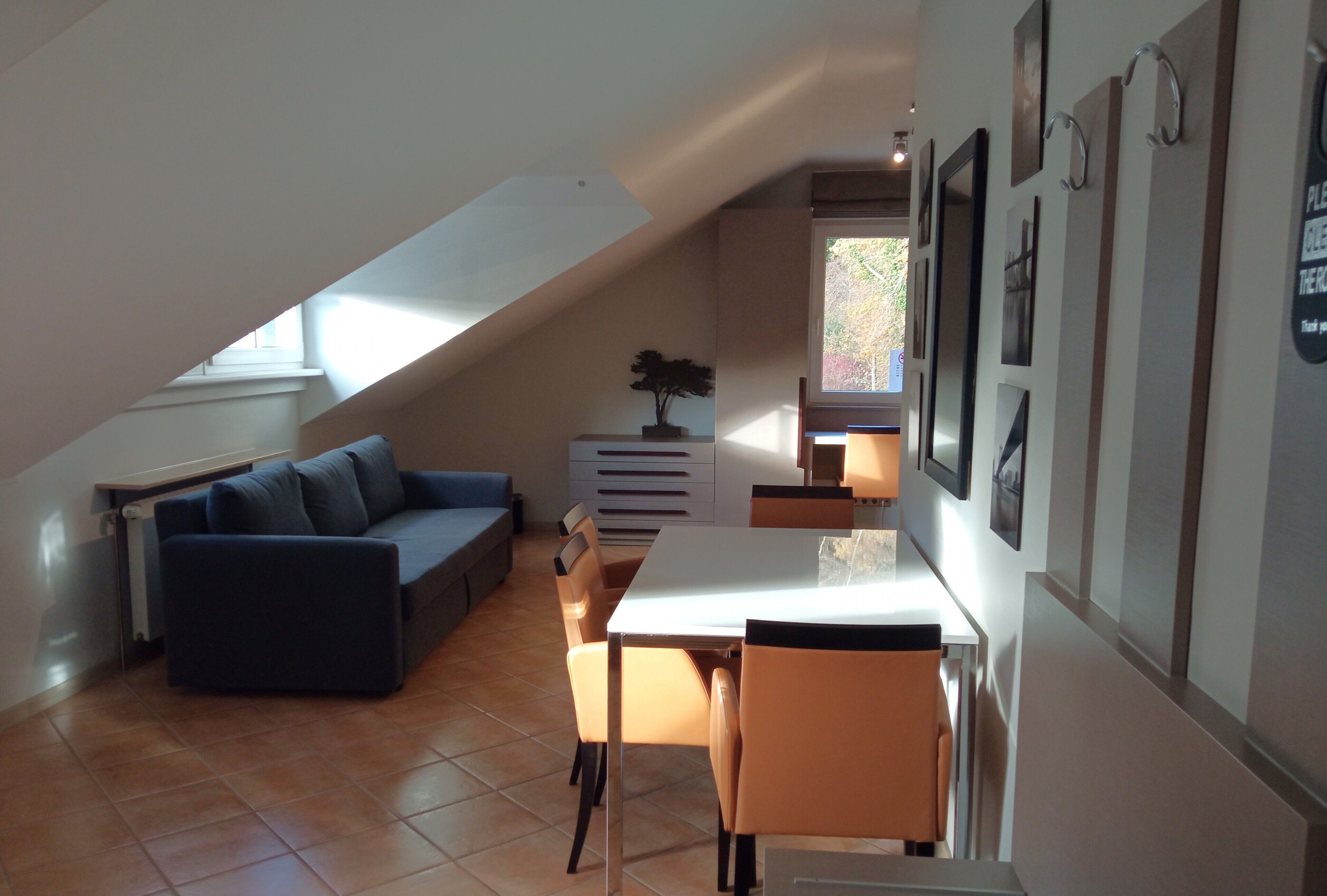 Een gezellige loft-kamer met een eethoek, een bank en een kleine tafel.