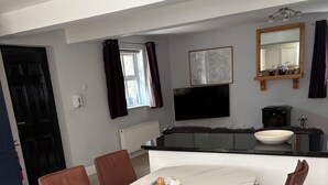 Eine moderne Küche mit weißem Marmorbelag, einem eingebauten Ofen und einem großen Fenster.