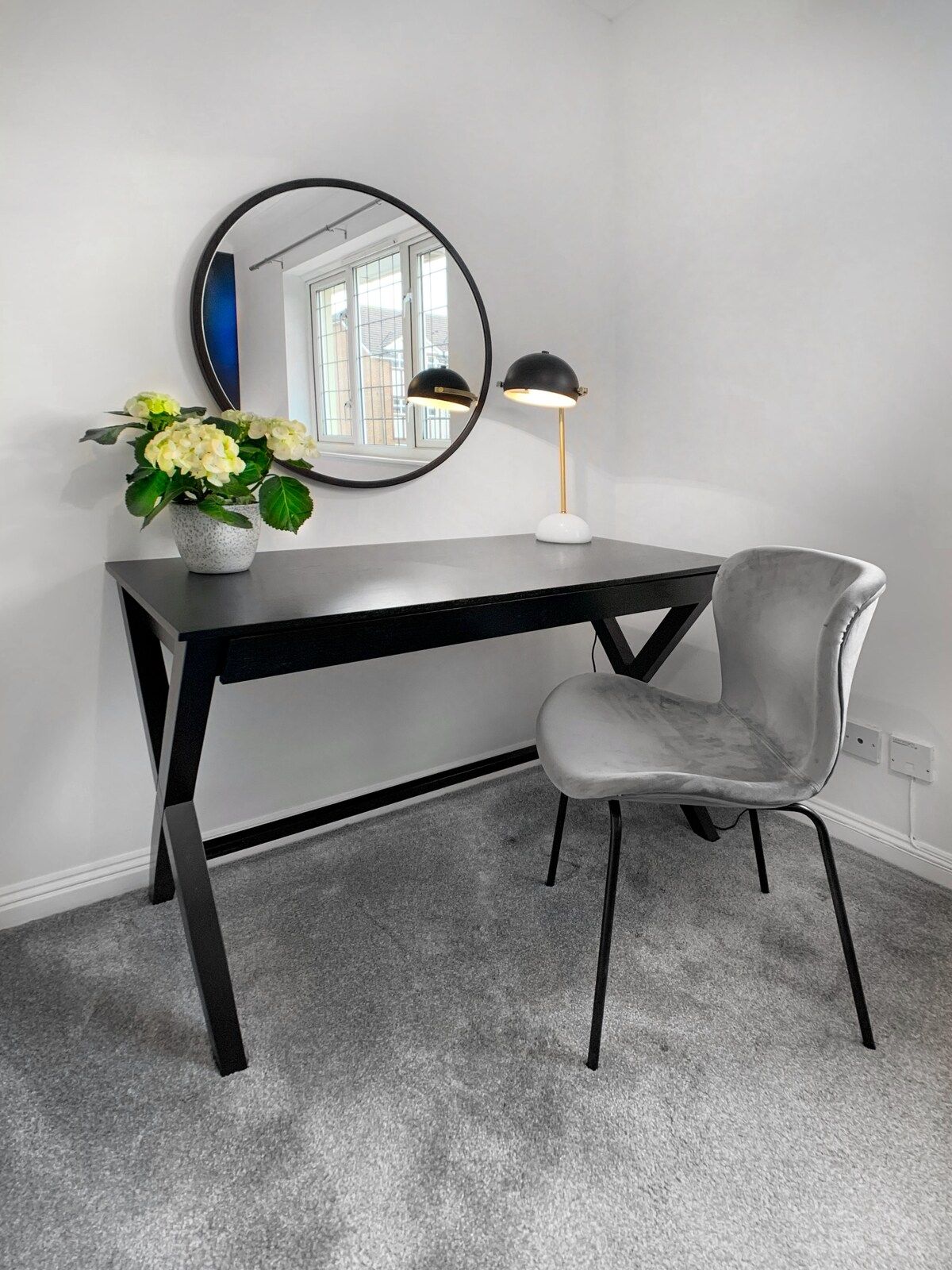 A modern room with a desk, chair, and a potted plant.