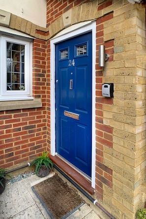 A blue door with the number 24, a mail slot, and a mailbox on the wall. - 2 BedTerrace House, Garden, Parking (Knaphill)