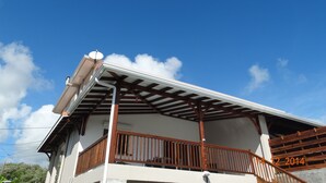 Een gebouw met twee verdiepingen, een balkon en een houten leuning.
