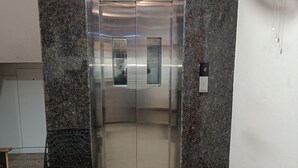 En elevator med metalfinish, digitalt display og kontrolpanel.