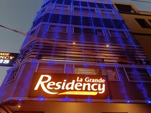 Un edificio con un letrero grande que dice "La Grande Residency" y un letrero más pequeño que dice "La Grande Cinema".