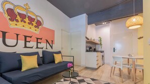 A modern living room with a sofa, a coffee table, and a dining area with a table and chairs. - MOT Rentals + Casa Chic - 9 Lux Units 36 pax (Palermo Chico)