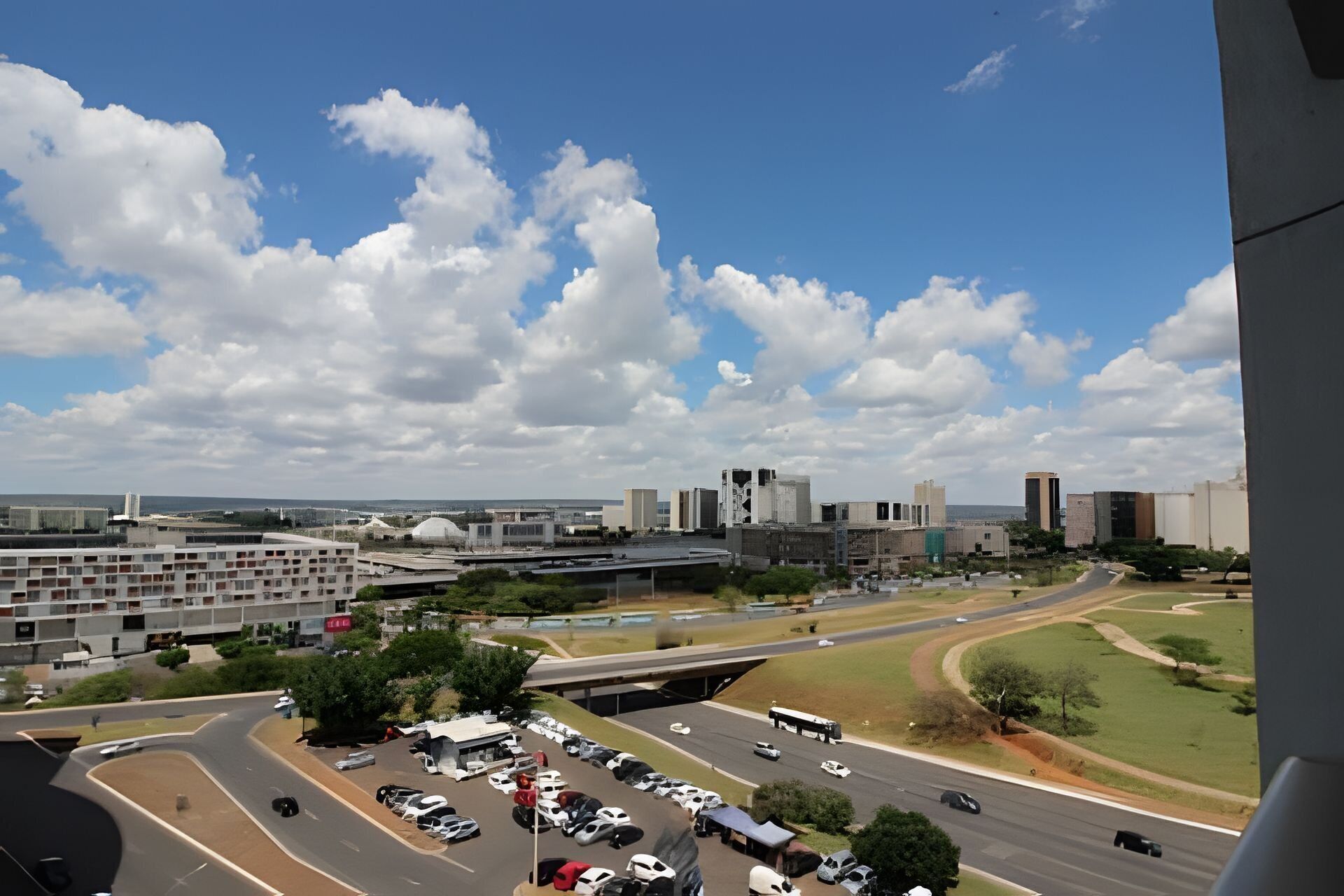 Uma paisagem urbana com estacionamento, ruas e edifícios.