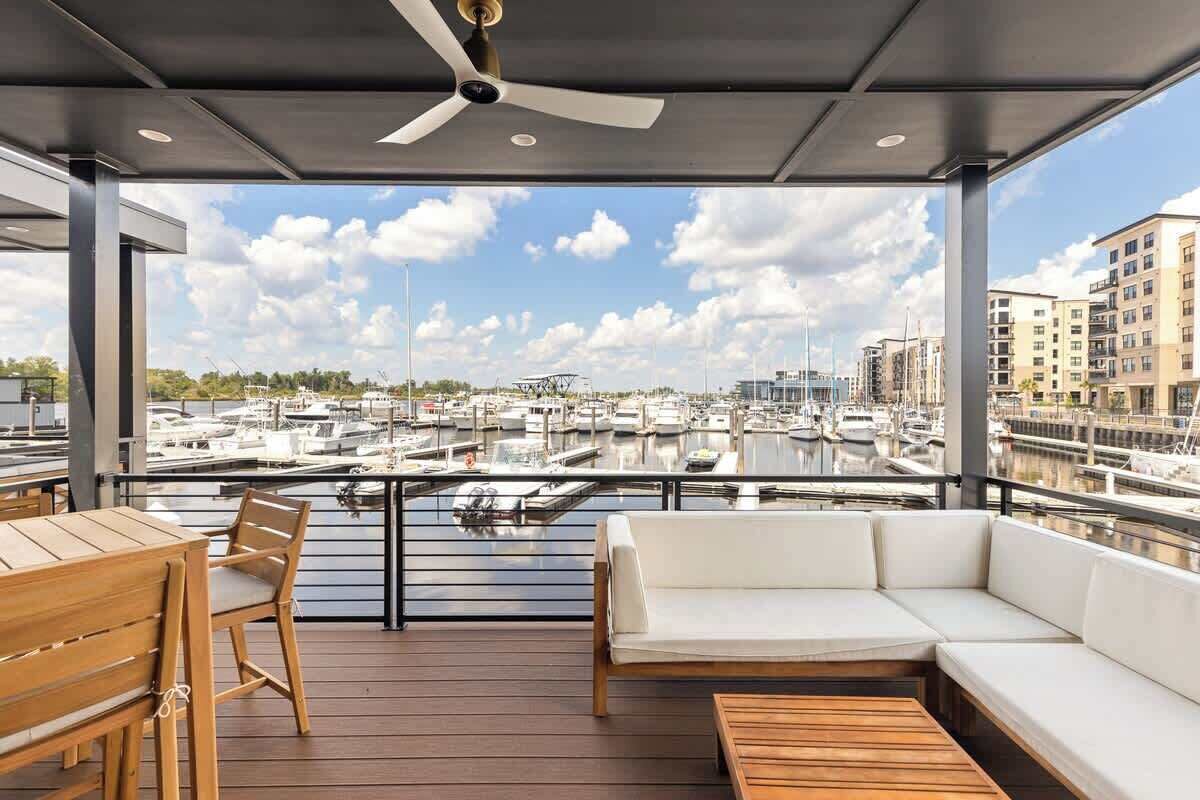 Un espace extérieur abrité, aménagé pour s’asseoir, avec vue sur un port de plaisance.
