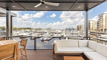 A covered outdoor seating area with a view of a marina.
