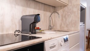 A modern kitchen with a Bosch dishwasher, a coffee maker, and a sink. - Taipas Tranquility: Cozy T0 by LovelyStay (Porto)