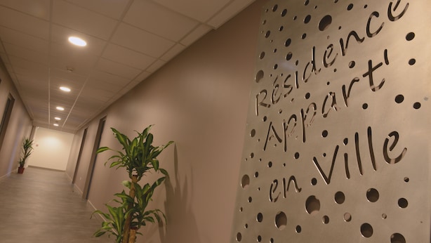 Een gang met een muur waarop 'Résidence Appart' en 'en Ville' staan.