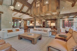 A spacious living area with a high ceiling, wooden beams, and a large window. - Silverfell Lodge at Northstar - TLUXP (Truckee)