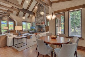 A spacious living area with a fireplace, large windows, and a stone accent wall. - Silverfell Lodge at Northstar - TLUXP (Truckee)