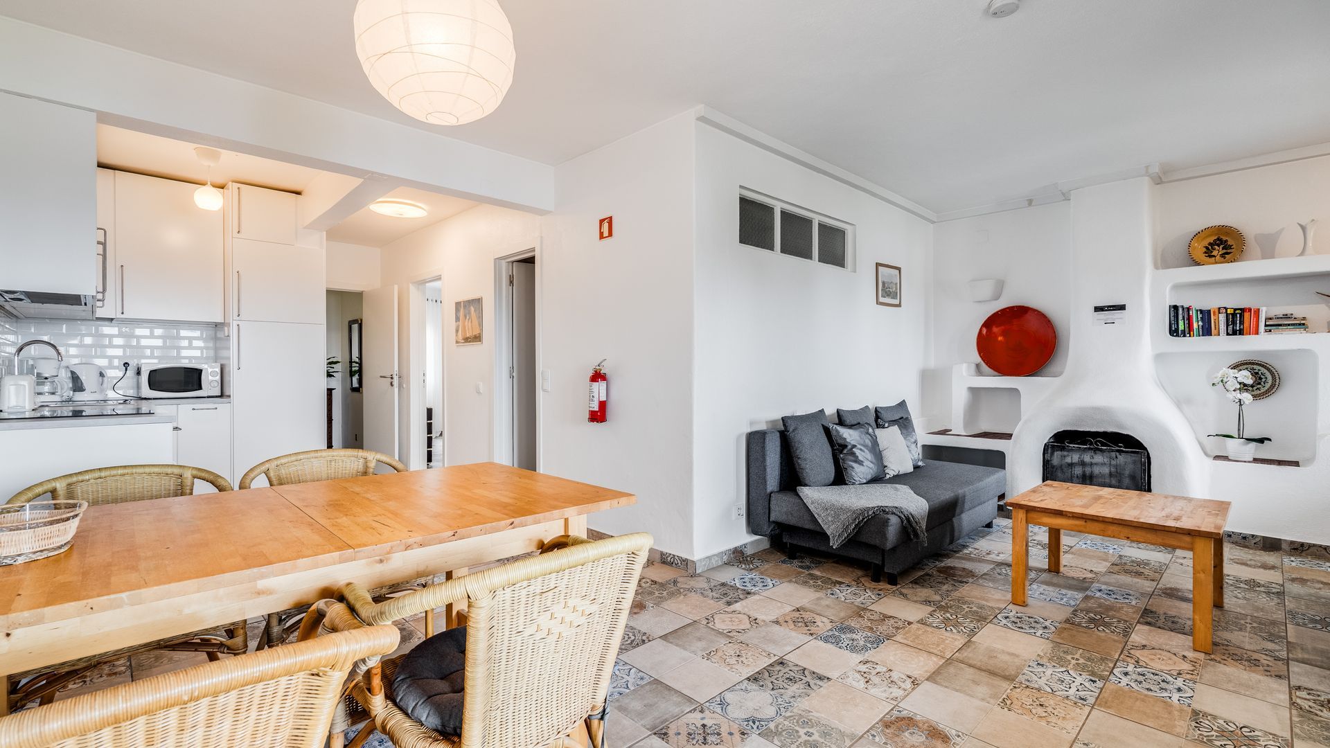 A modern living space with a dining area, kitchen, and seating area.
